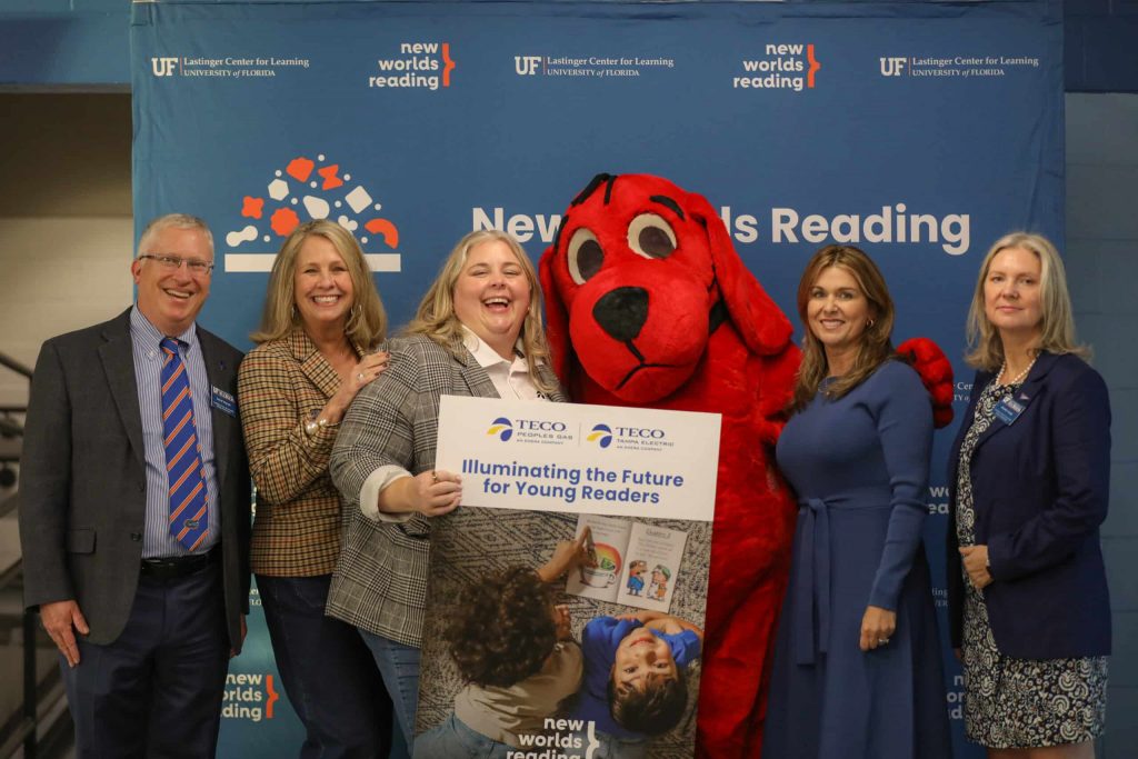 NWRI-Tampa-Teco-2025-10-scaled Event sponsors representing Peoples Gas and Tampa Electric (TECO) pose with Clifford the Big Red Dog. In the center, there is a sign that references this a partnership.